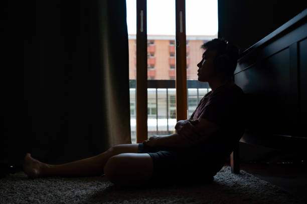 istock Stressed Asian man sitting on the floor 1334359241