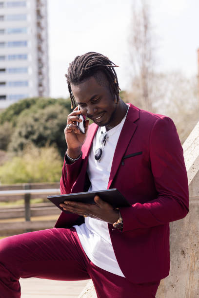 istock businessman using a tablet and talking on phone 1334359742