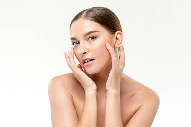 istock Smooth fresh glowing skin woman touching her face in white isolated studio background for beauty and skincare concepts 1334359764