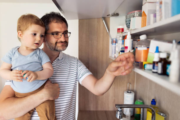薬のキャビネットから薬を服用しているお父さんと彼の赤ちゃんの息子 - medicine cabinet 写真 ストックフォトと画像