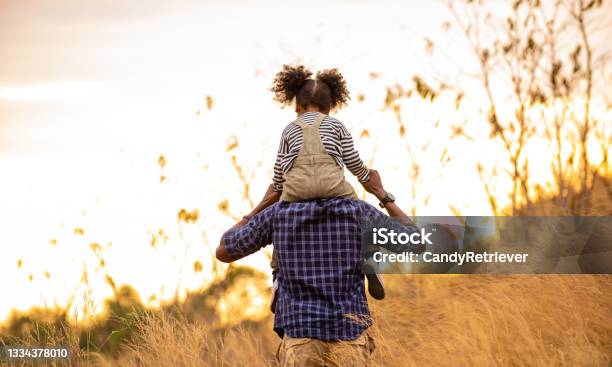Mixed Race Family Hiking Together On The Meadow At Summer Sunset Stock Photo - Download Image Now