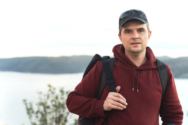 Portrait of a mature man with a backpack on the hill.
