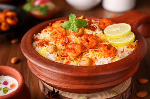 Prawn or shrimp biryani, Fish biryani. Spicy and delicious Malabar biryani or Hydrabadi biryani, Dum Biriyani, pulao basmati rice, herbs, raitha for Ramadan Kareem, Eid. Indian food
