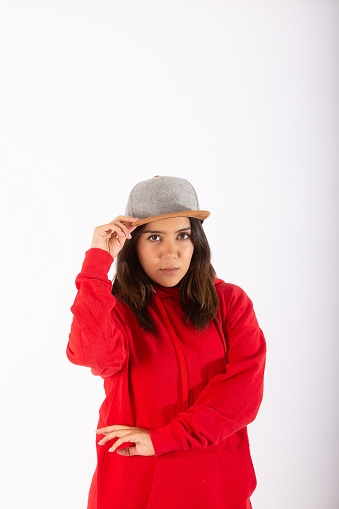 Young woman wearing red sweatshirt with gray cap in modern style.