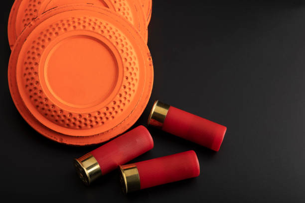 istock Clay shooting target and shotgun bullets on black background ,Clay Pigeon target game 1334384077