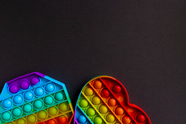 istock Colorful antistress sensory toy fidget push pop it on black background with copy space 1334385042