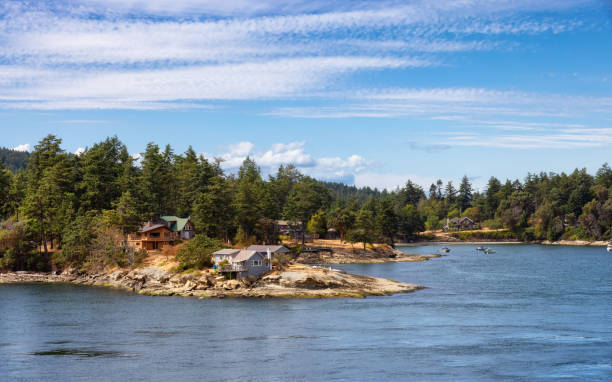 Panoramic View of a Cosy Homes on the rocky coast during a sunny summer day. Taken on Galiano Island near Vancouver Island, BC, Canada.