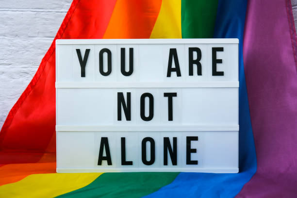 istock Rainbow flag with lightbox and text YOU ARE NOT ALONE. Rainbow lgbtq flag made from silk material. Symbol of LGBTQ pride month. Equal rights. Peace and freedom 1334400007