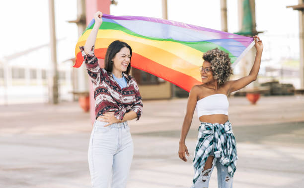 istock multiracial girlfriends with rainbow flag, gay pride 1334402218