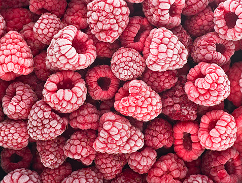 Berries background - Frozen raspberries covered with hoarfrost. Summer berries, top view.