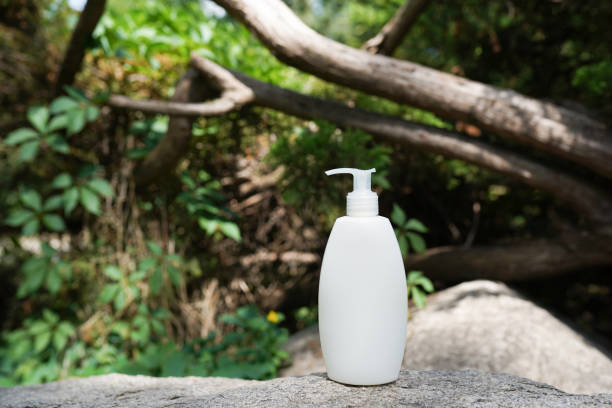 istock White blank cosmetic bottle with cream, moisturizing lotion or shampoo on stone background with green leaves. Natural Organic Spa Cosmetic Beauty Concept. Mockup 1334404789