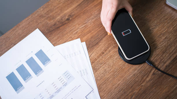 istock Charging mobile phone battery with wireless charging device in the table. Smartphone charging on a charging pad. Mobile phone near wireless charger Modern lifestyle technology concept. 1334406761