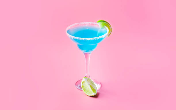 istock Blue cocktail with tequila, liqueur, lime juice, salt and ice, pink background, negative space 1334408669
