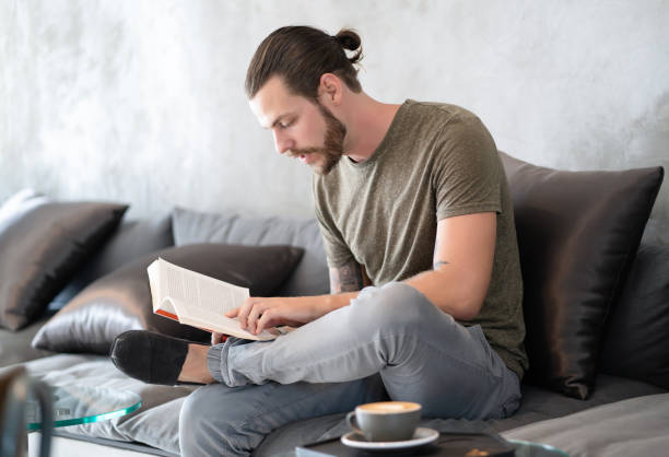 istock Young bearded hipster guy reading book at cafe.Lifestyle Concept. 1334410280