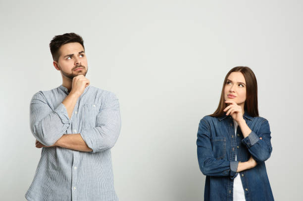 Pensive couple on light background. Thinking about answer for question Pensive couple on light background. Thinking about answer for question asking stock pictures, royalty-free photos & images