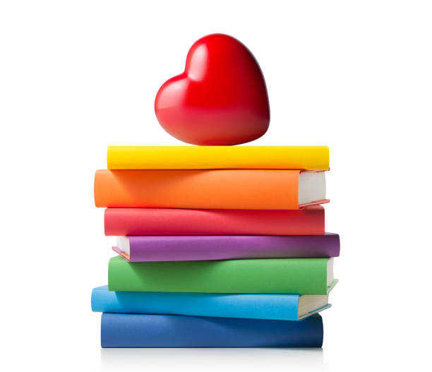 Stack of colored books with heart Stack of colored books with heart isolated on a white background. book heart shape valentines day copy space stock pictures, royalty-free photos & images