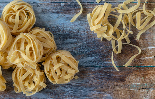 istock dry tagliatelle on old wooden table 1334411712