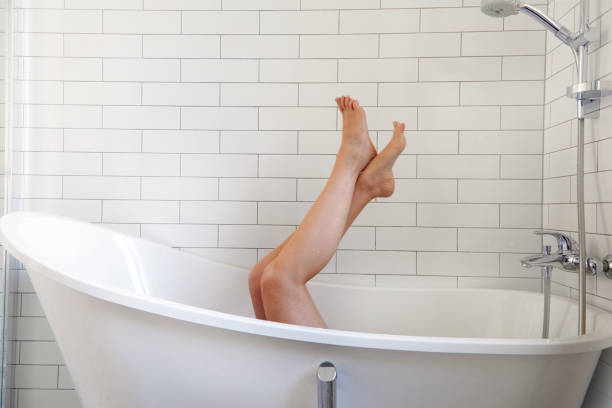 istock Anonymous barefoot woman chilling in white bathtub 1334411993