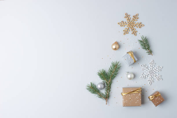 istock Christmas tree shape made with gifts in craft and Christmas decorations on grey background. Flat lay, copy space 1334415708