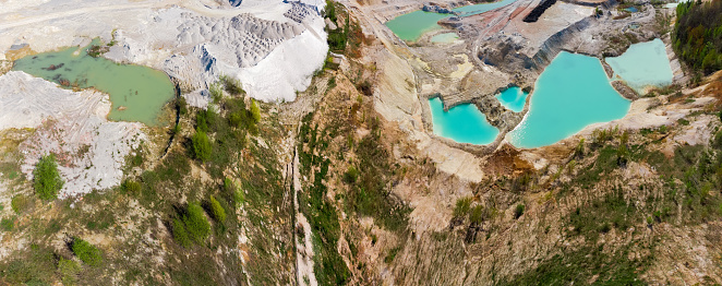Part of china clay quarry partly filled with turquoise water in summer day, aerial panoramic view