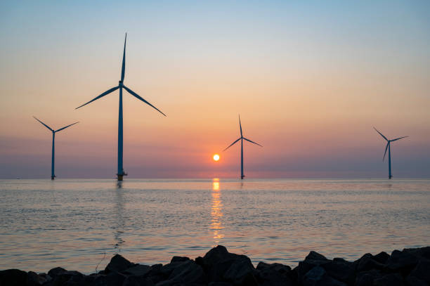 istock Wind turbines in an offshore wind park producing electricity during sunset. 1334416888