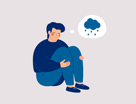 Unhappy man hugs his knees and sits on the floor with rainy cloud above his. Sad boy is crying.  Male character feels depression, sorrow, grief. Mental disorder or illness concept. Vector illustration