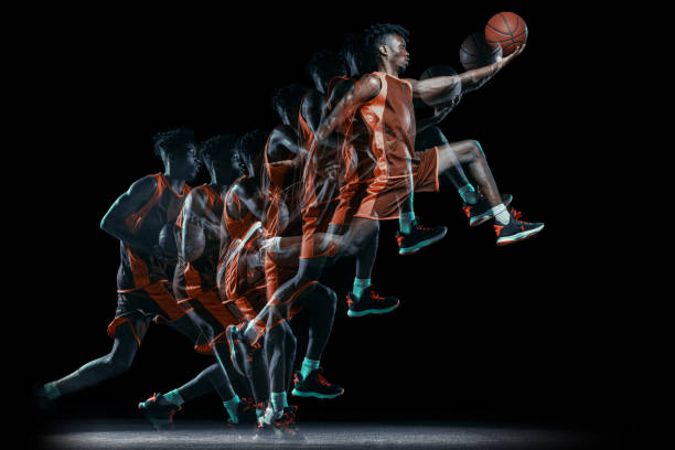 joven africano, jugador de baloncesto en movimiento con balón aislado sobre fondo negro. efecto estroboscópico - stroboscopic image fotografías e imágenes de stock