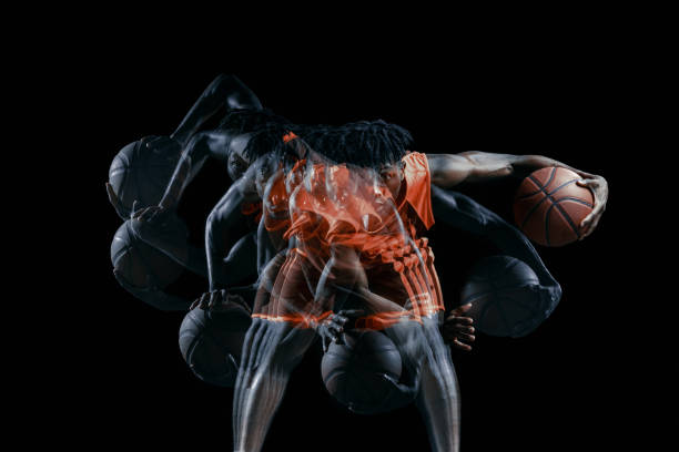 ein junger afrikaner, basketballspieler in bewegung mit ball isoliert über schwarzem hintergrund. stroboskopische wirkung - stroboscopic image stock-fotos und bilder