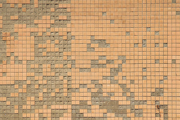 istock Big shabby textured wall is lined with old Soviet beige crumbling ceramic tiles. Dangerous crumbling facade. 1334421065