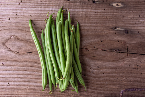 Bunch of green beans on a wooden table