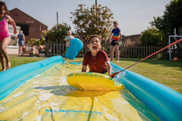 jogando no slip n slide - inflatable slide sliding child - fotografias e filmes do acervo