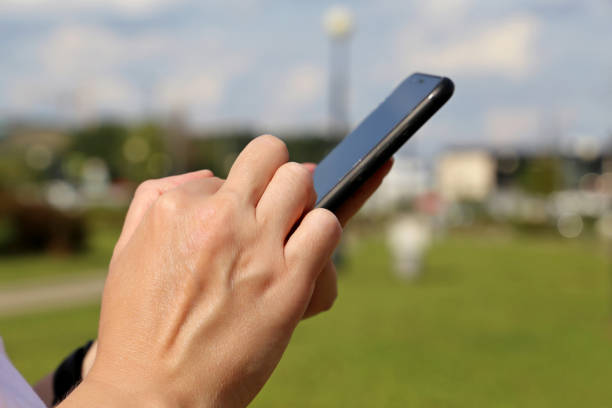istock Smartphone in female hands close up on blurred city background 1334422065
