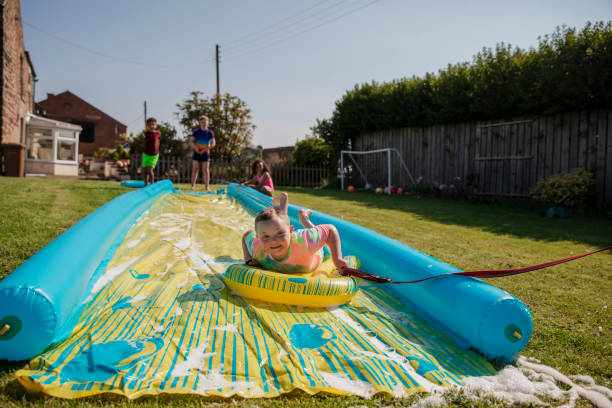 s’amuser sur le slip n slide - inflatable slide sliding child photos et images de collection