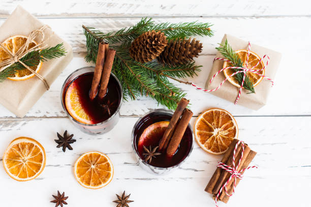 istock Festive greeting card with mulled wine, wrapped gift boxes and wonter traditional spices on white table 1334426826