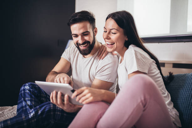 istock Young couple using tablet in a hotel room while lying on the bed. 1334429280
