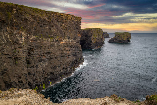 rocky cliffs in kilkee at sunset - kilkee imagens e fotografias de stock