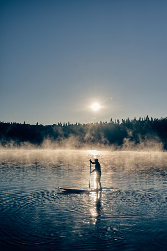 istock Hombre remando en el tablero de sup en el río de la montaña 1334432275