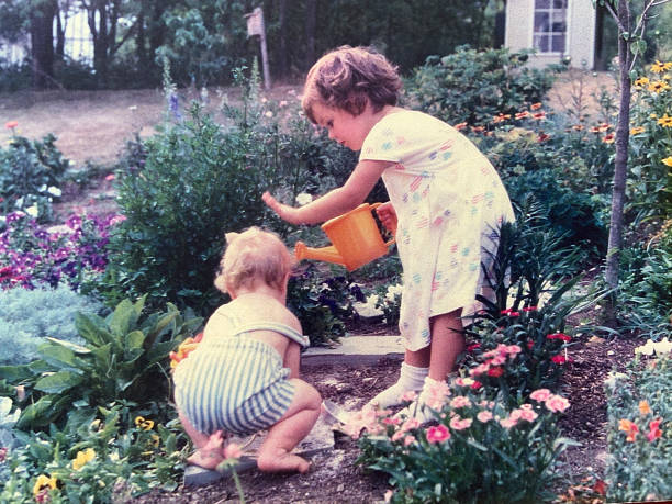 big sister warning little brother 1988 in garden - horizontaal fotos stockfoto's en -beelden
