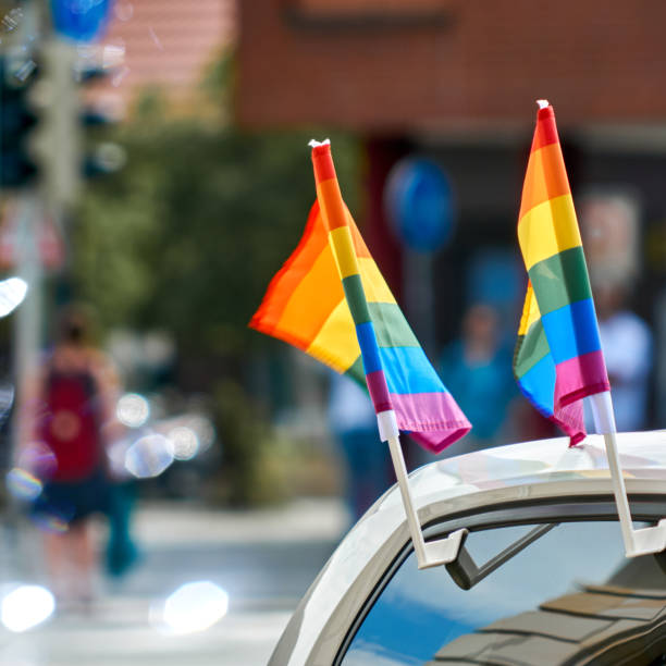 istock Small rainbow flags are attached to the side window of a car, selective focus 1334435691