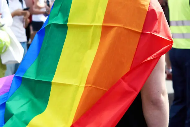 Photo of Close up of rainbow flag cape worn over shoulders by CSD participant