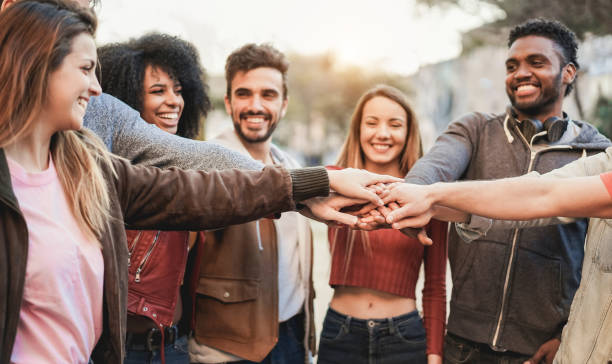 istock Multiracial young people celebrating together while stacking hands outdoor - Focus on hands 1334435922