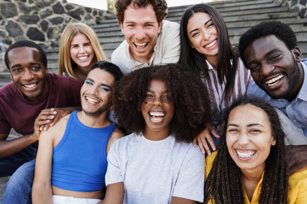 Young diverse people having fun outdoor laughing together - Diversity concept - Main focus on african girl face stock photo