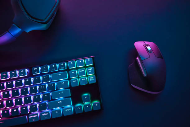 istock View of pastel neon color backlighted computer keyboard and mouse from above. 1334435971