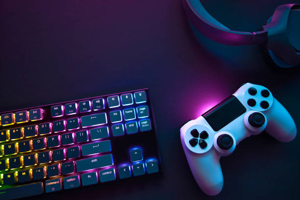 Top down view of colorful illuminated gaming accessories laying on table. Top down view of colorful illuminated gaming accessories laying on table. Professional computer game playing, esport business and online world concept. games console stock pictures, royalty-free photos & images