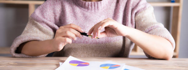 istock woman holding pen and graph 1334437329
