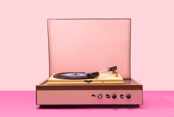 Gramophone record player from sixties. Turntable for single vinyl with pink bottom with light pink background. Gramophone record player from sixties. Turntable for single vinyl with pink bottom with light pink background. digital jukebox stock pictures, royalty-free photos & images