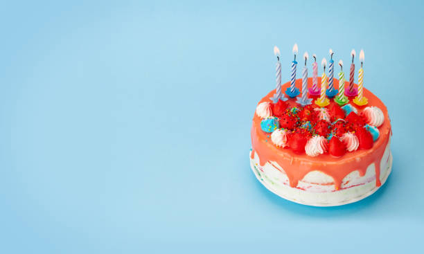 istock Birthday cake with burning candles on a blue 1334444856
