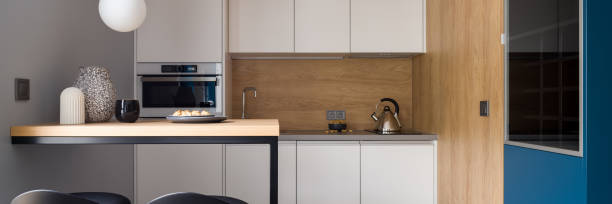 istock Stylish and modern kitchen with wood decor, panorama 1334446782