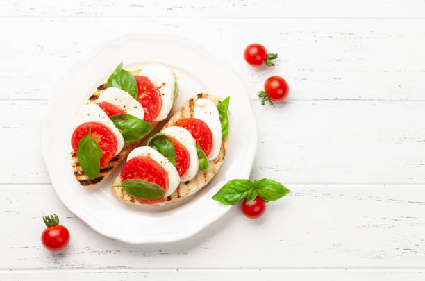 salada caprese com mussarela, manjericão e tomates de jardim - mozzarella caprese salad tomato italian cuisine - fotografias e filmes do acervo
