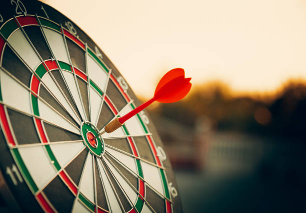 bullseye target or dart board has red dart arrow throw hitting the center of a shooting for business targeting and winning goals business concepts. bullseye target or dart board has red dart arrow throw hitting the center of a shooting for business targeting and winning goals business concepts. dartboard bulls eye darts dart stock pictures, royalty-free photos & images